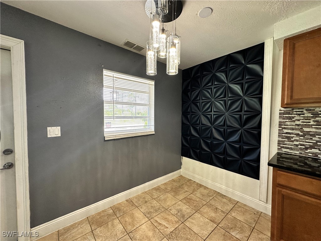 818 Sheldon Avenue Lehigh Acres, FL 33936 - Photo 12 of 43 a view of a hallway with a chandelier