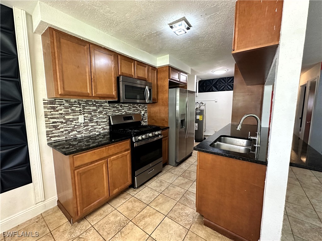 818 Sheldon Avenue Lehigh Acres, FL 33936 - Photo 13 of 43 a kitchen with stainless steel appliances granite countertop a stove refrigerator and sink