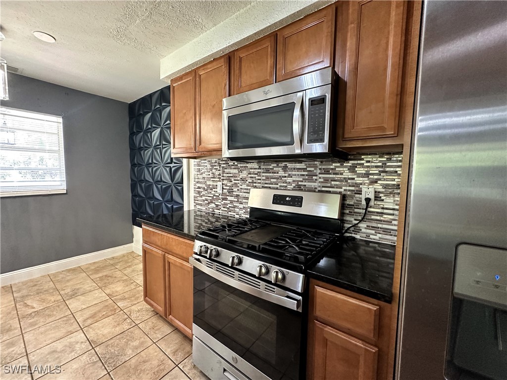 818 Sheldon Avenue Lehigh Acres, FL 33936 - Photo 14 of 43 a kitchen with stainless steel appliances granite countertop a stove microwave and sink