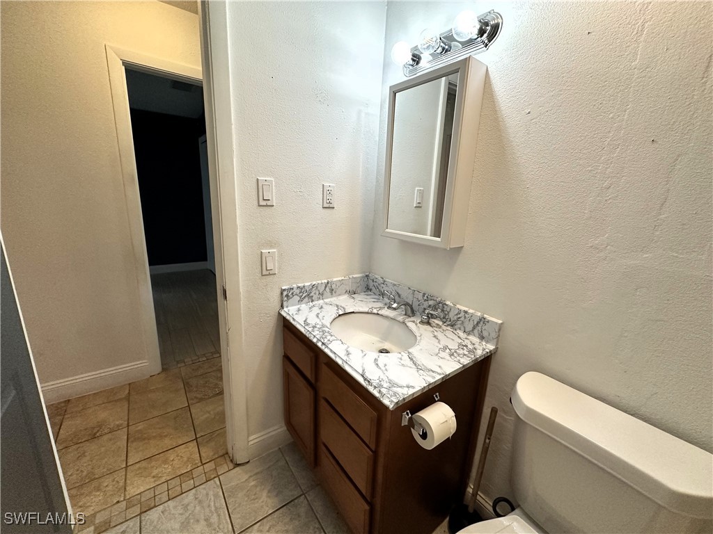 818 Sheldon Avenue Lehigh Acres, FL 33936 - Photo 21 of 43 a bathroom with a sink a toilet and mirror