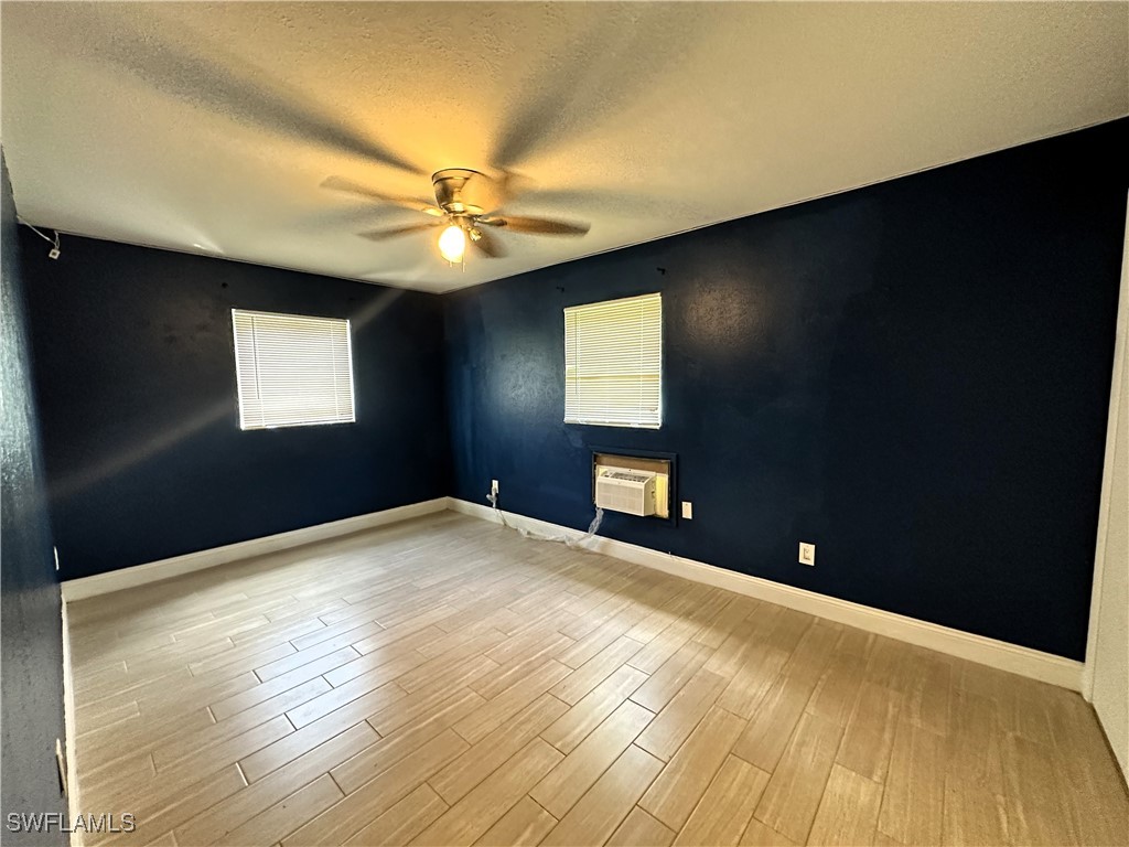 818 Sheldon Avenue Lehigh Acres, FL 33936 - Photo 22 of 43 a view of an empty room with window and wooden floor
