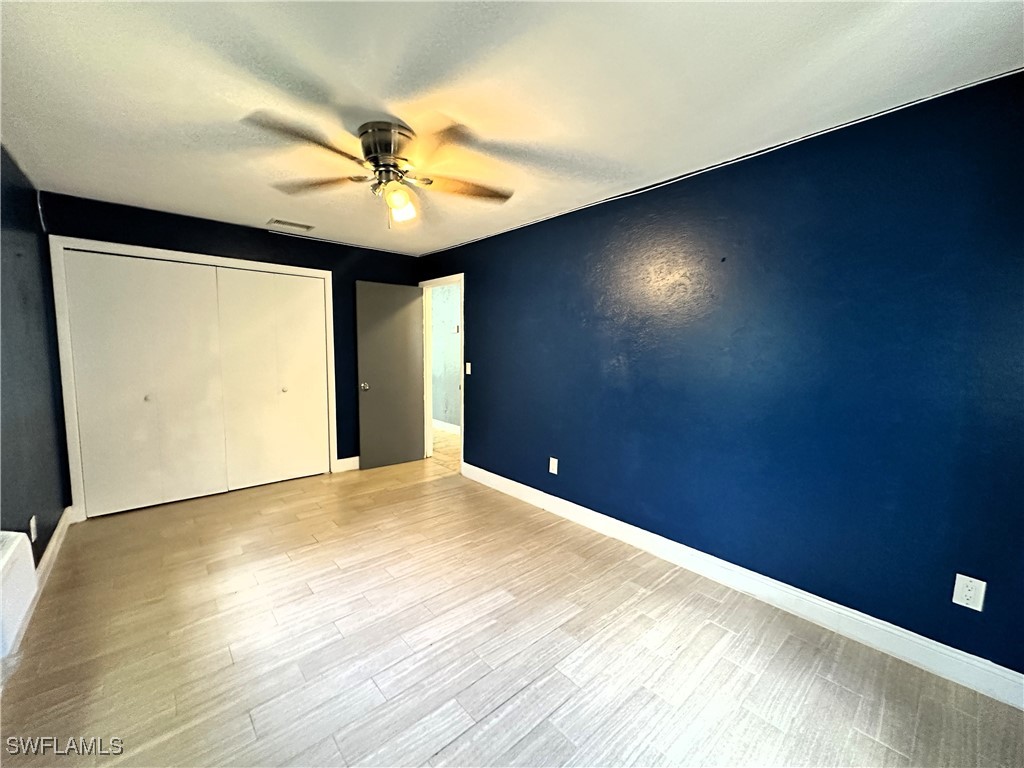 818 Sheldon Avenue Lehigh Acres, FL 33936 - Photo 23 of 43 a view of an empty room with wooden floor and a window