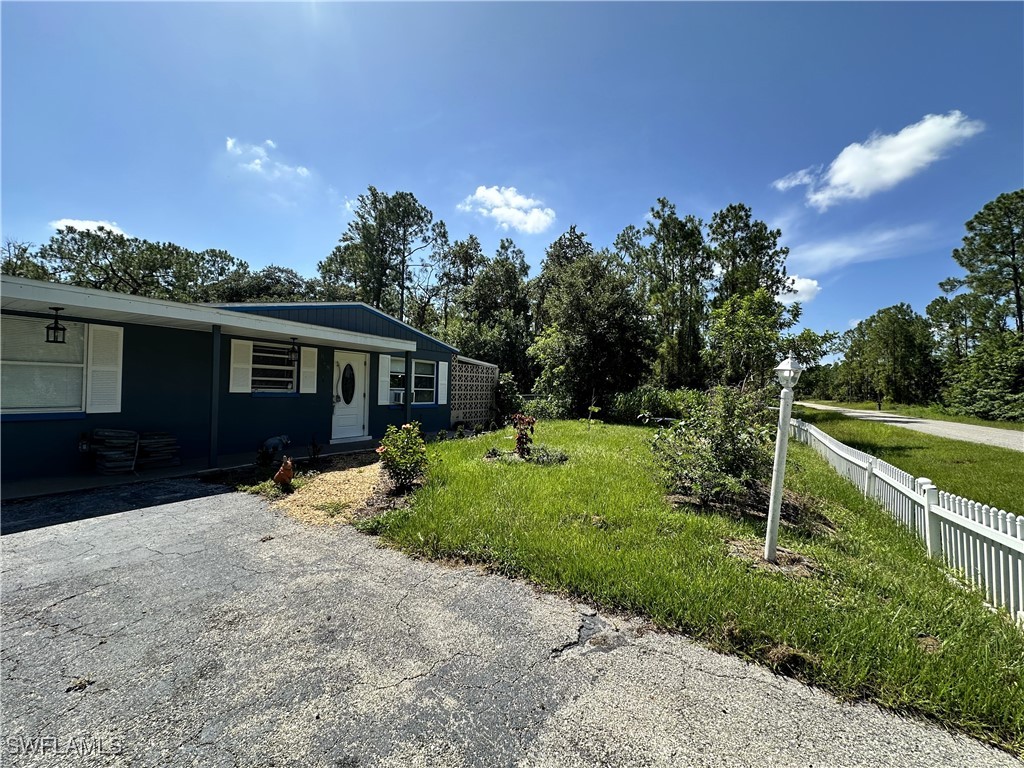 818 Sheldon Avenue Lehigh Acres, FL 33936 - Photo 3 of 43 a house view with a sitting space and garden