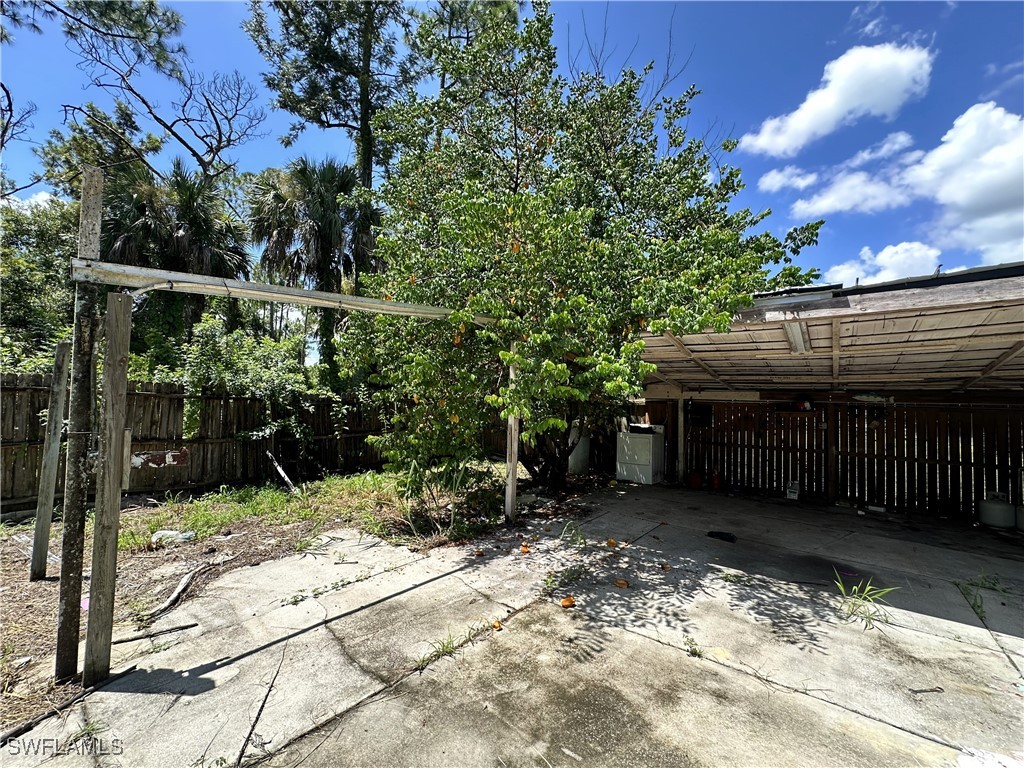 818 Sheldon Avenue Lehigh Acres, FL 33936 - Photo 31 of 43 a backyard of a house with lots of green space and wooden fence