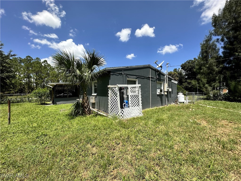818 Sheldon Avenue Lehigh Acres, FL 33936 - Photo 35 of 43 a view of a house with a yard and a garden