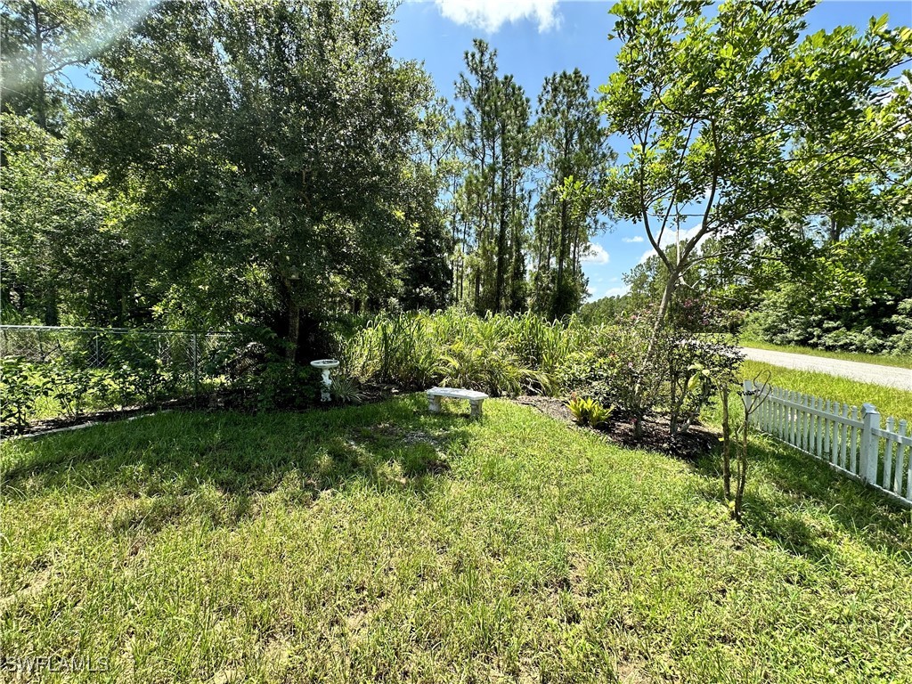 818 Sheldon Avenue Lehigh Acres, FL 33936 - Photo 38 of 43 a garden with trees in the background