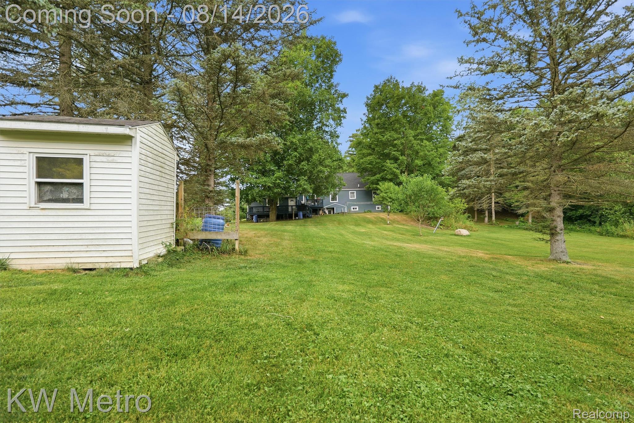 201 South Maple Leaf Road Lapeer, MI 48446 - Photo 43 of 70 Expansive green lawn with mature trees and a detached shed featuring white siding
