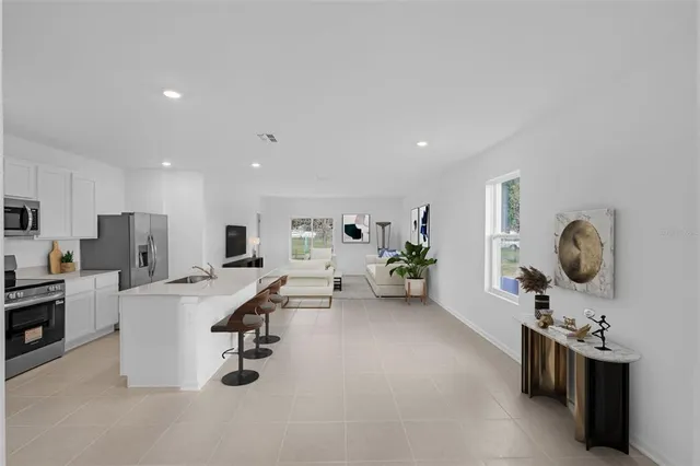 a living room with stainless steel appliances kitchen island granite countertop furniture a rug kitchen view and living room view