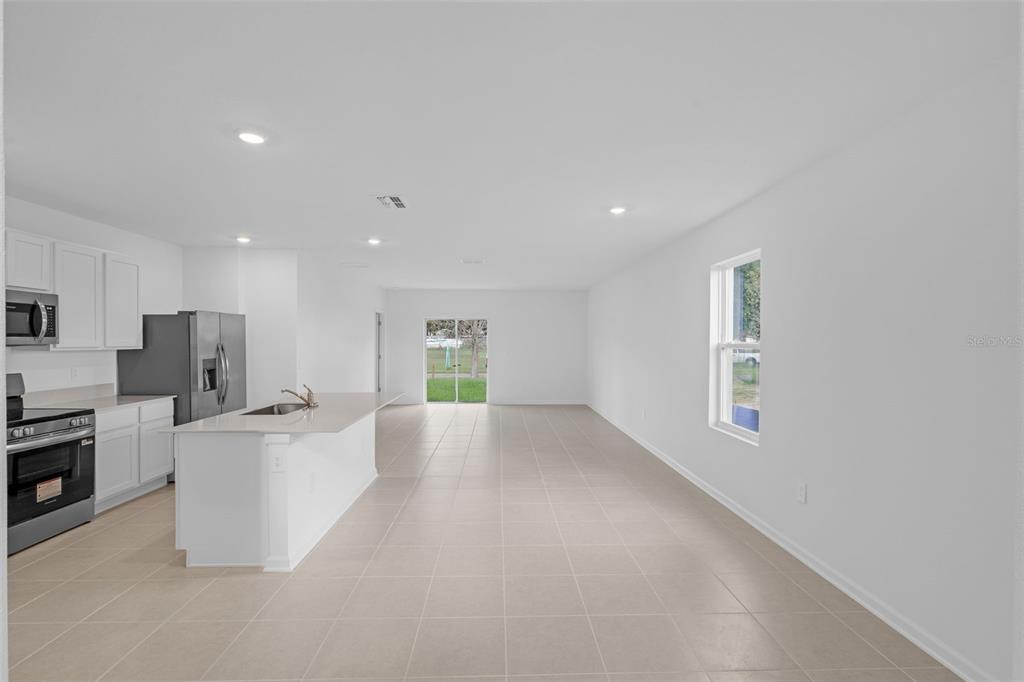 5428 Meadow Walk Drive Davenport, FL 33837 - Photo 7 of 24 a large white kitchen with stainless steel appliances a large window