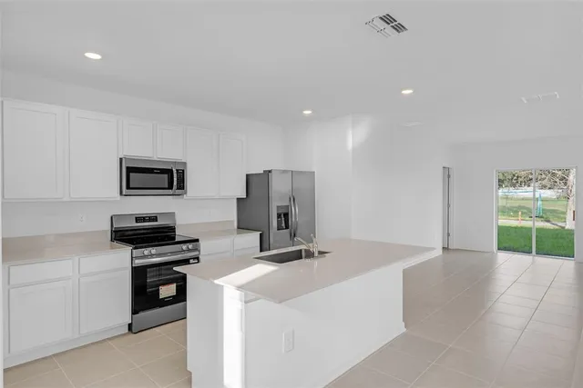 a kitchen that has a sink and a stove top oven