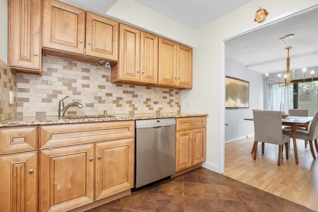 a kitchen with granite countertop wooden cabinets stainless steel appliances and a window