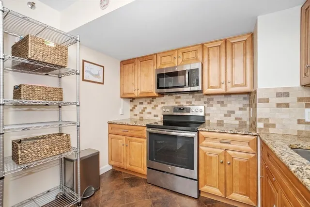 a kitchen with stainless steel appliances granite countertop a stove a sink and a microwave