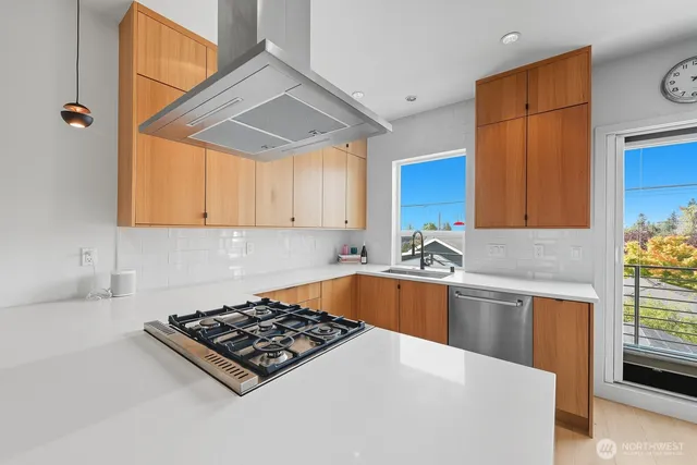 a kitchen with stainless steel appliances a stove a sink and a microwave