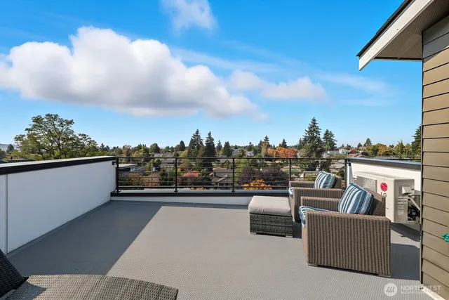 a view of roof deck with couches and sky view