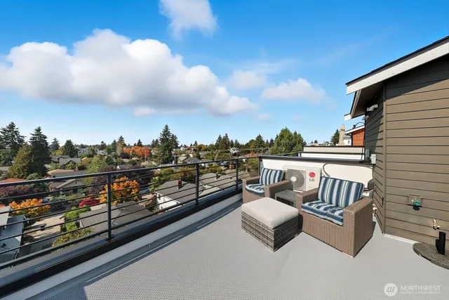 a view of a roof deck with couches and sky view