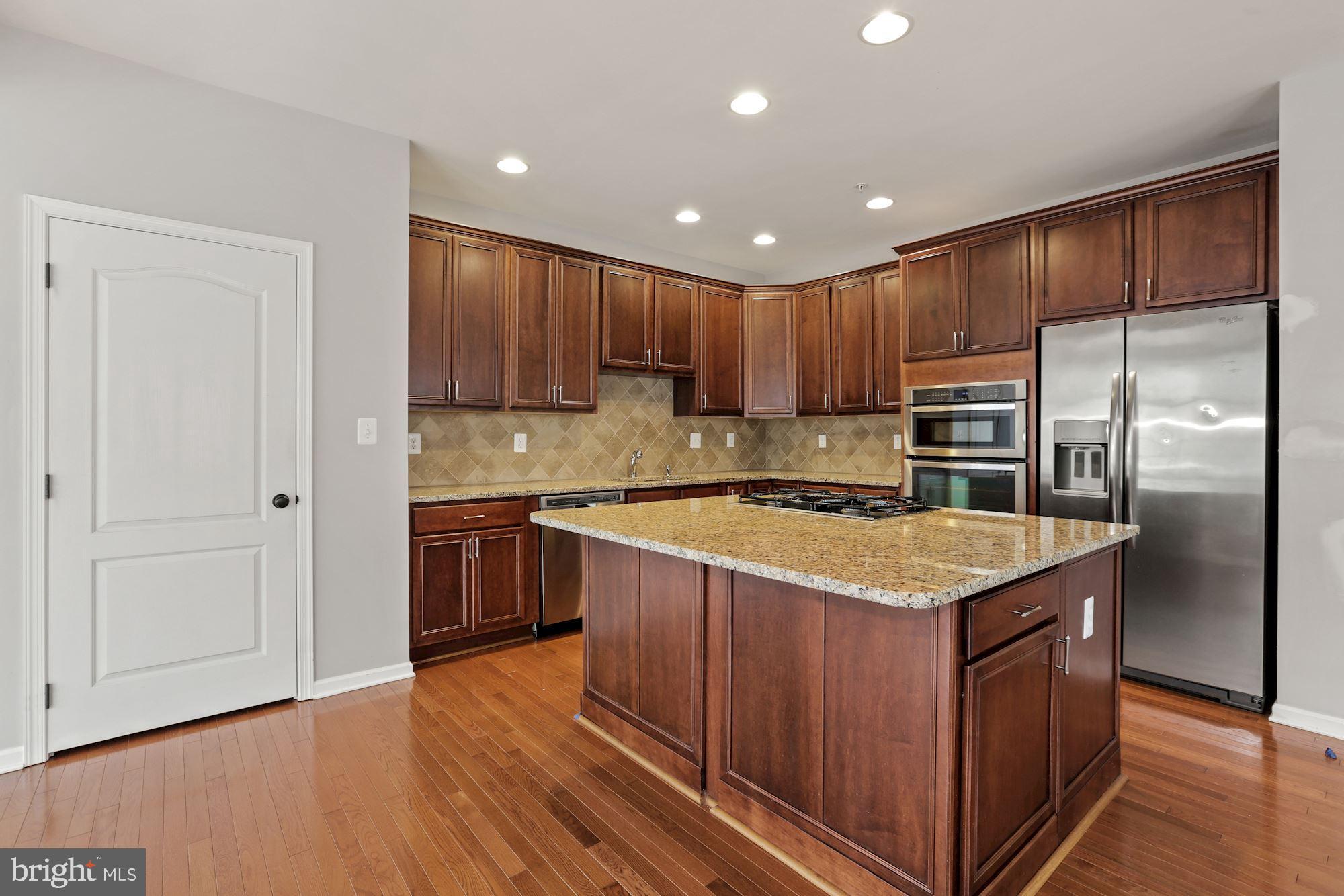11007 Buggy Path Upper Marlboro, MD 20772 - Photo 17 of 18 a kitchen with kitchen island granite countertop wooden cabinets and stainless steel appliances