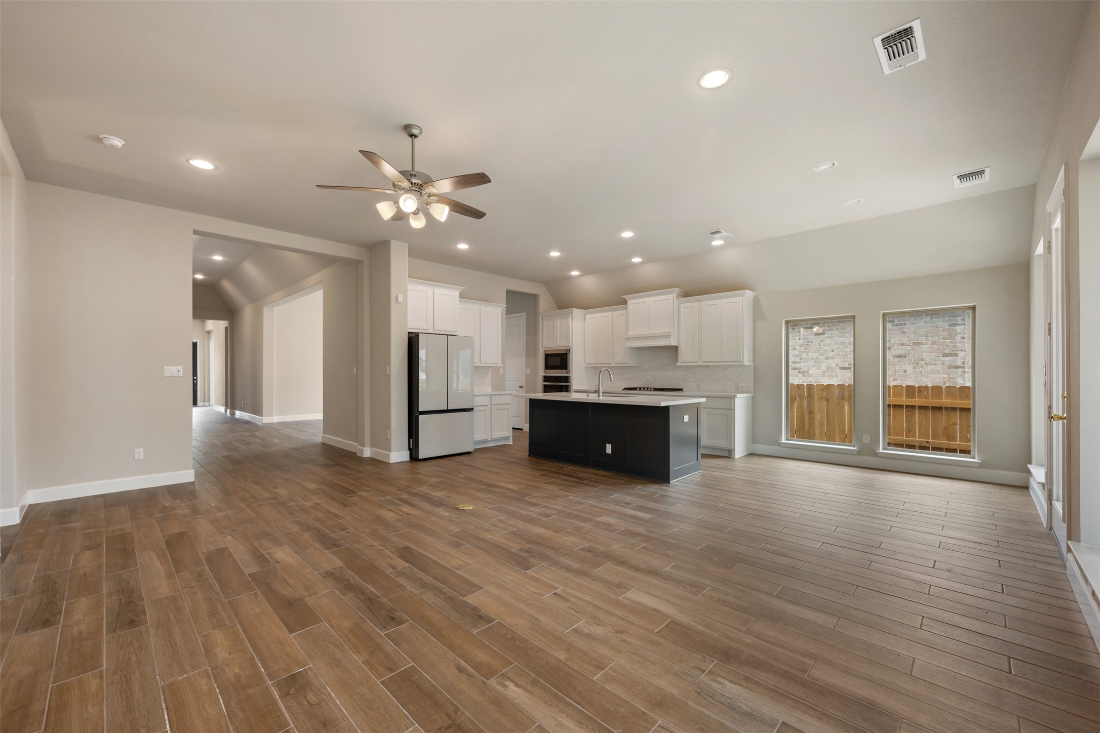 104 Anejo Bluff Georgetown, TX 78628 - Photo 21 of 40 a view of an empty room with wooden floor and a kitchen