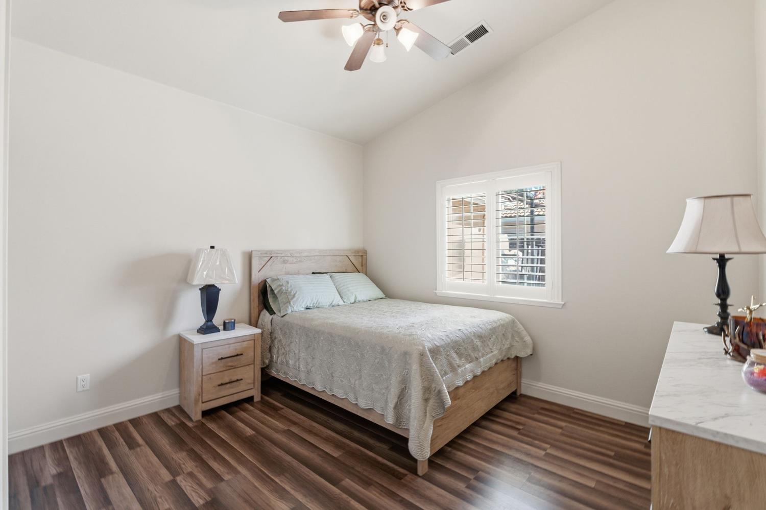 3296 Hollow Avenue Madera, CA 93637 - Photo 19 of 45 a bedroom with a bed and a chandelier
