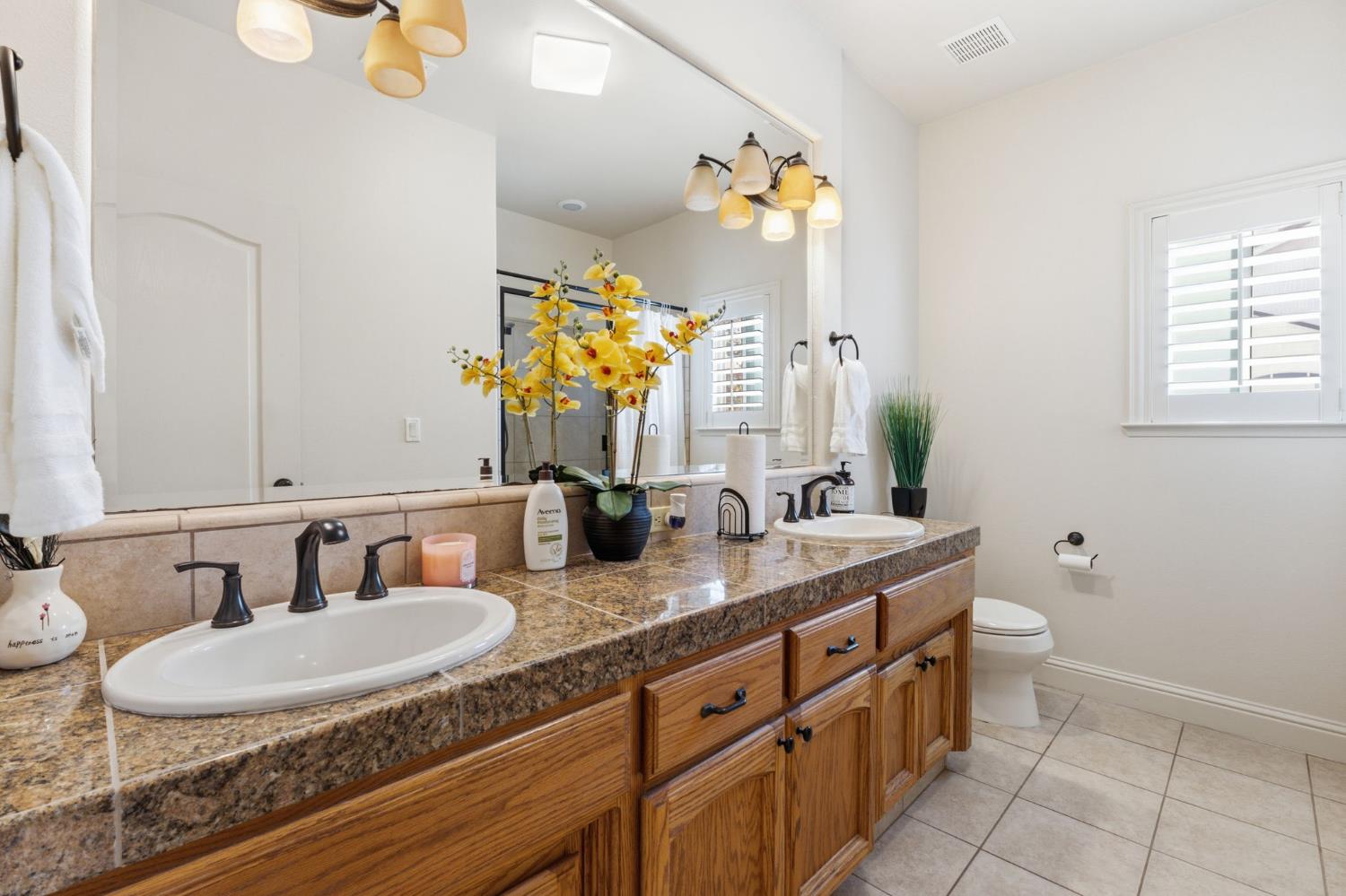 3296 Hollow Avenue Madera, CA 93637 - Photo 21 of 45 a bathroom with a granite countertop double vanity sink and a mirror