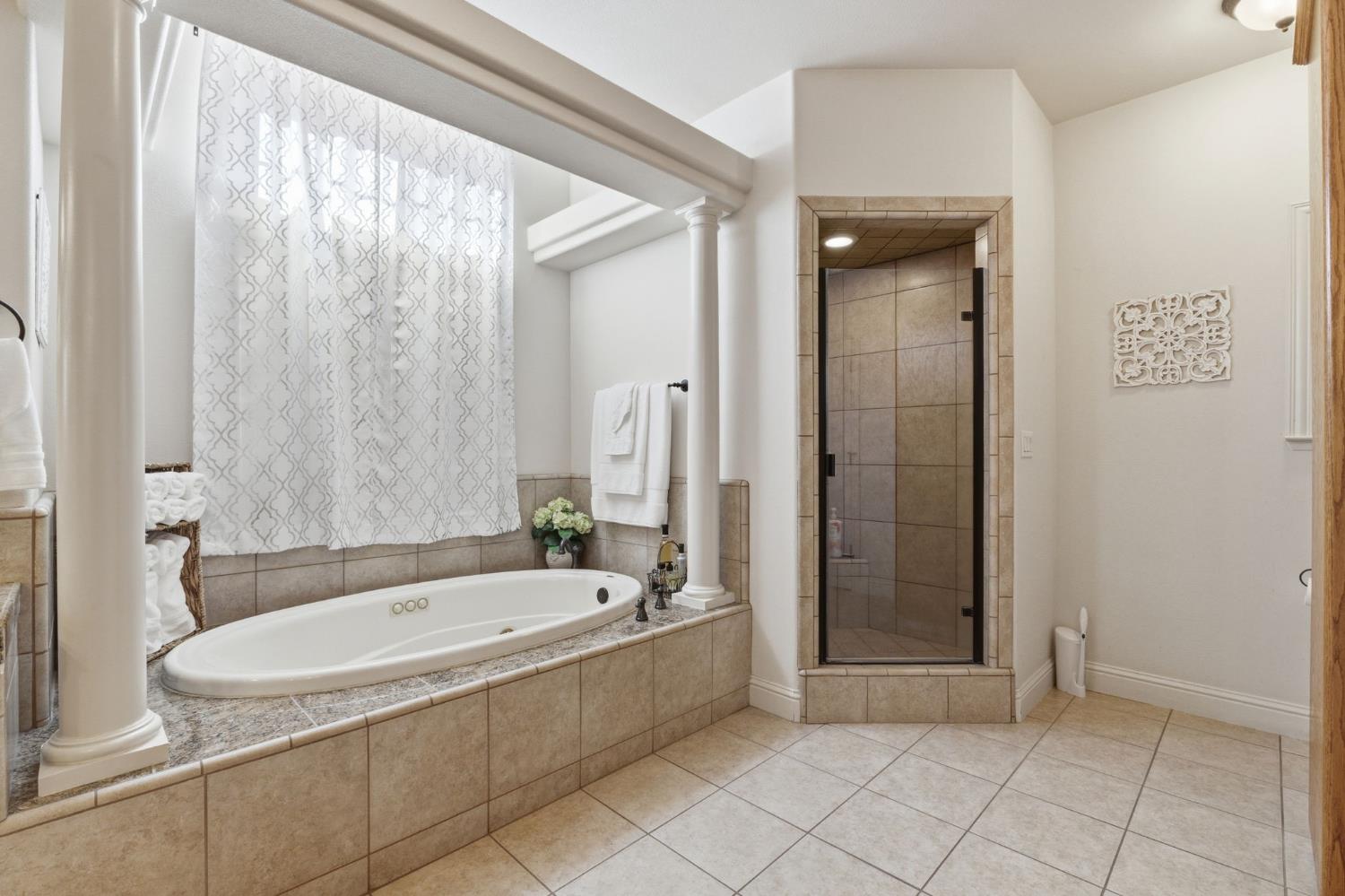 3296 Hollow Avenue Madera, CA 93637 - Photo 26 of 45 a white bath tub sitting next to a bathroom