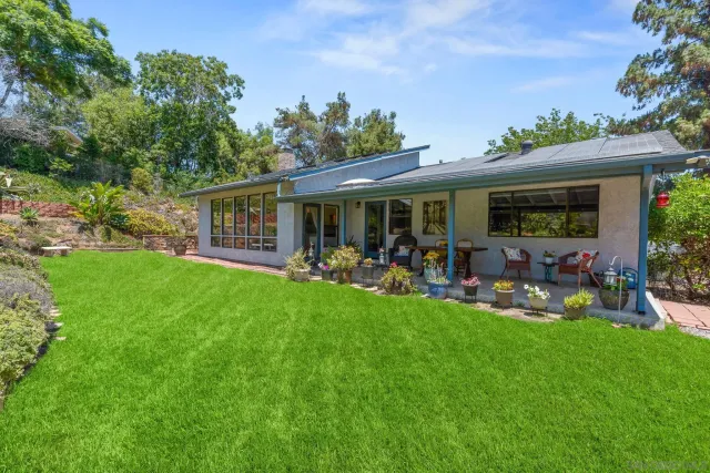 a view of a house with backyard and sitting area