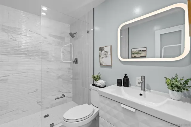 a living room with furniture and a dining table with kitchen appliances