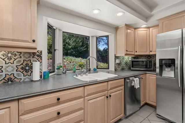 a kitchen with white cabinets and window