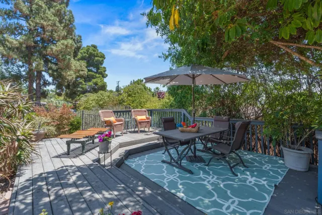 a roof deck with table and chairs under an umbrella