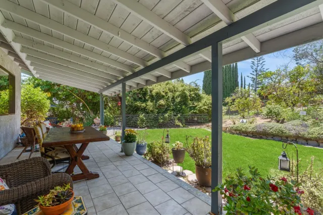 a view of a patio with table and chairs potted plants with wooden floor and seating space