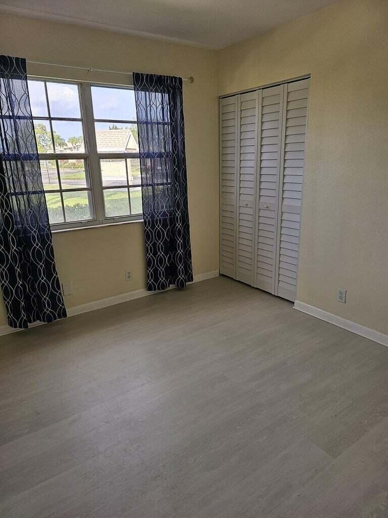 1554 Southeast Royal Green Circle, Unit 101 Port St. Lucie, FL 34952 - Photo 4 of 8 an empty room with windows and closet