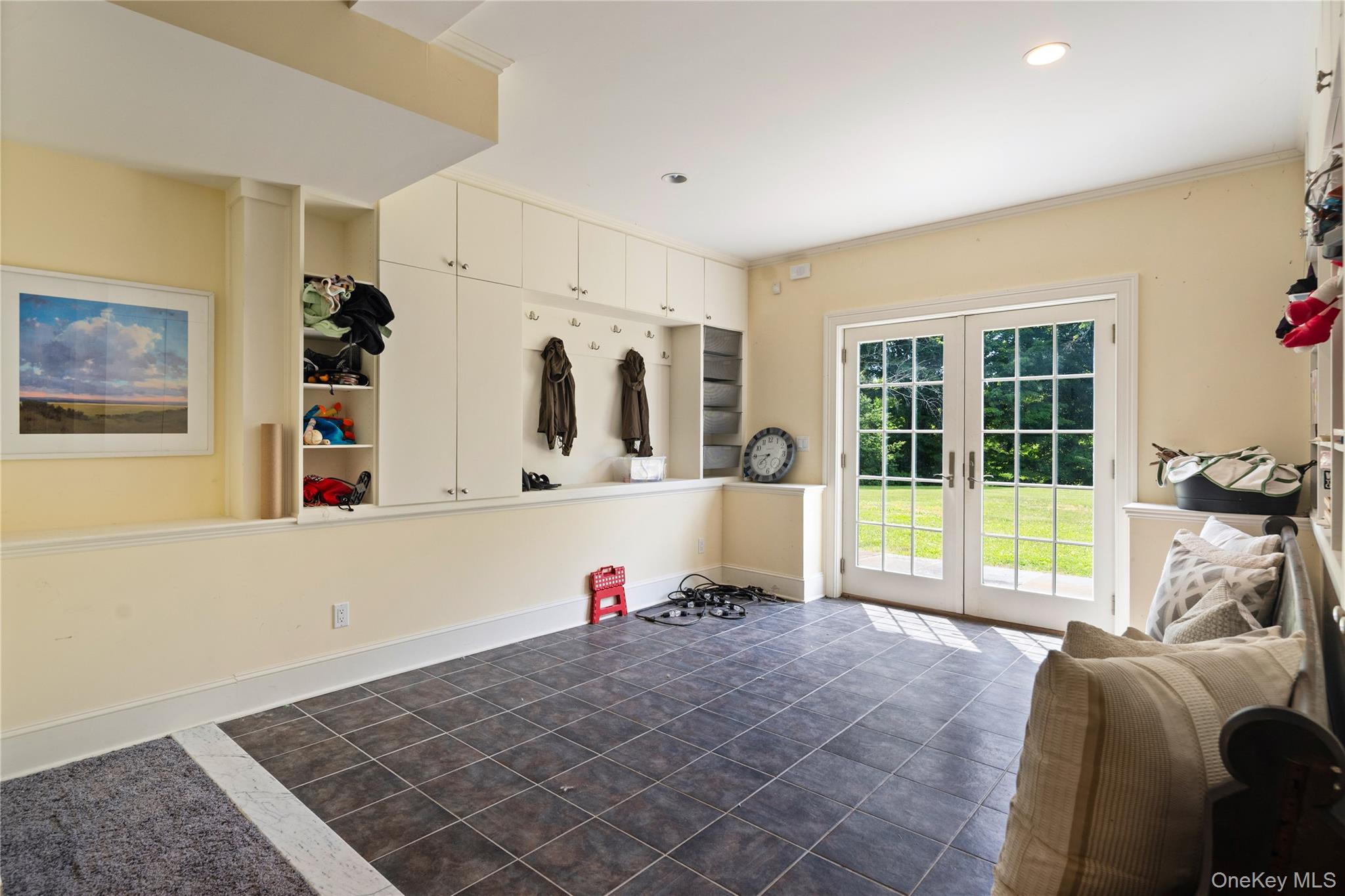 77 Byram Ridge Road Armonk, NY 10504 - Photo 42 of 48 Lower level mudroom with storage cabinetry, coat hooks and cubbys, French doors out to back yard, tile floor