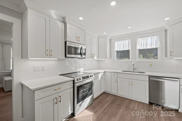 a kitchen with granite countertop white cabinets and white appliances