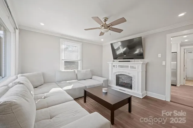 a living room with furniture a flat screen tv and a fireplace