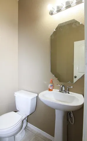 a bathroom with a toilet sink and mirror