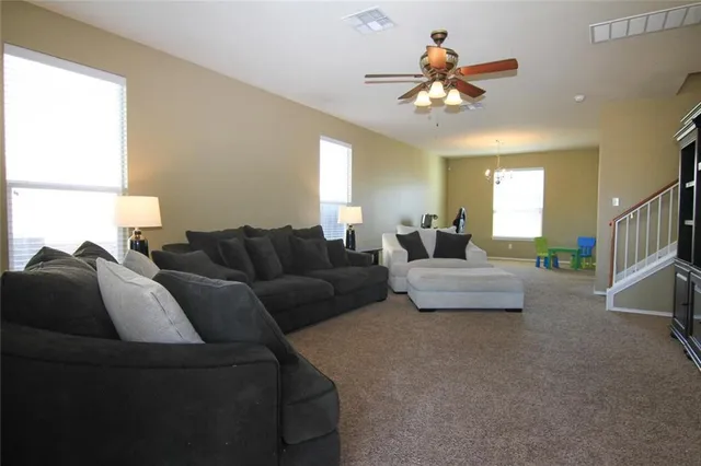 a living room with furniture and a chandelier