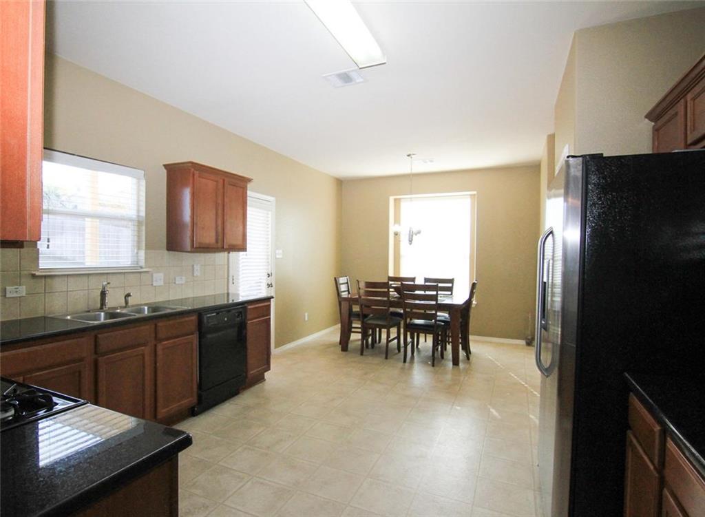 2705 Overton Street Round Rock, TX 78665 - Photo 6 of 19 a kitchen with granite countertop a sink stove and refrigerator