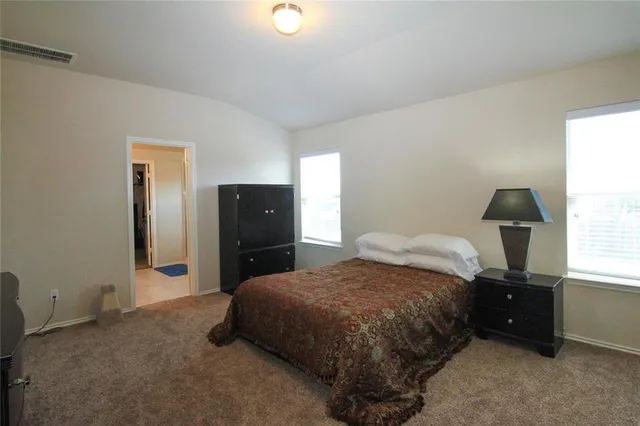 a bedroom with a bed and a lamp