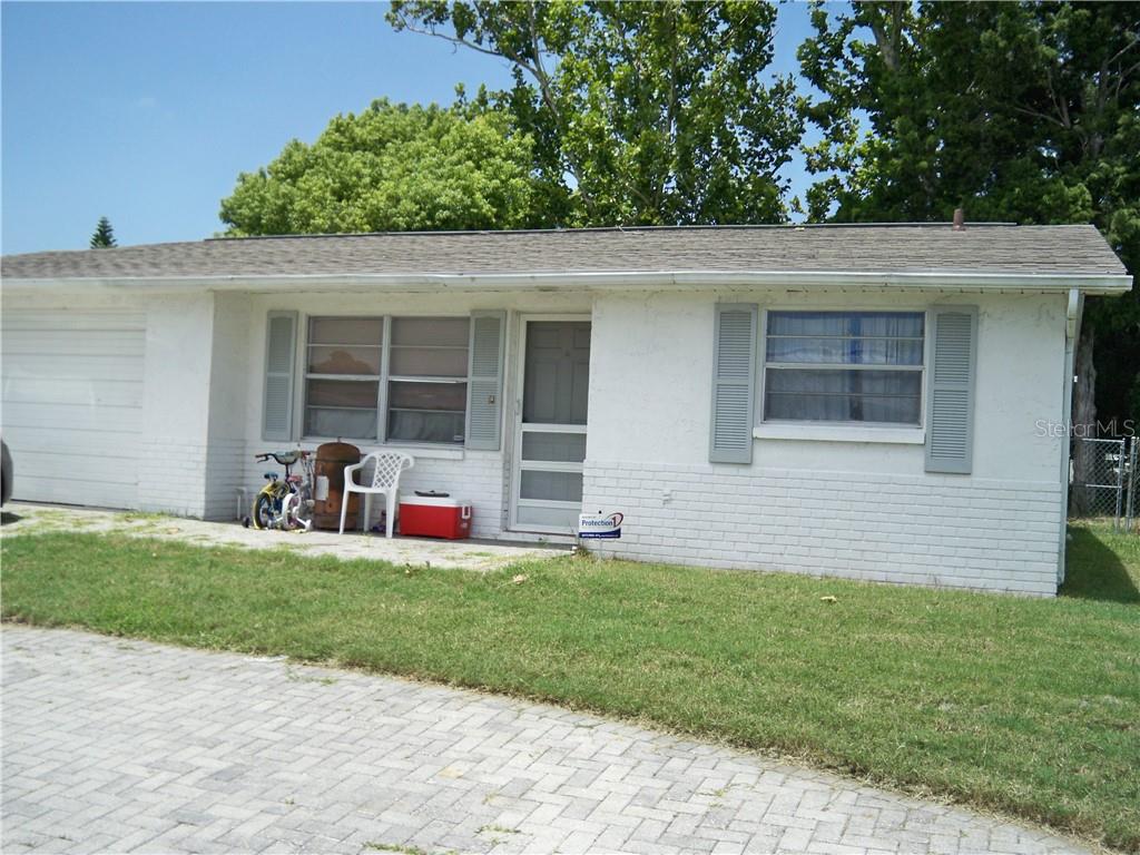 a view of a house with a yard and a large tree