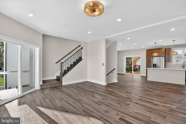 a kitchen with stainless steel appliances granite countertop a sink a stove and a wooden floors