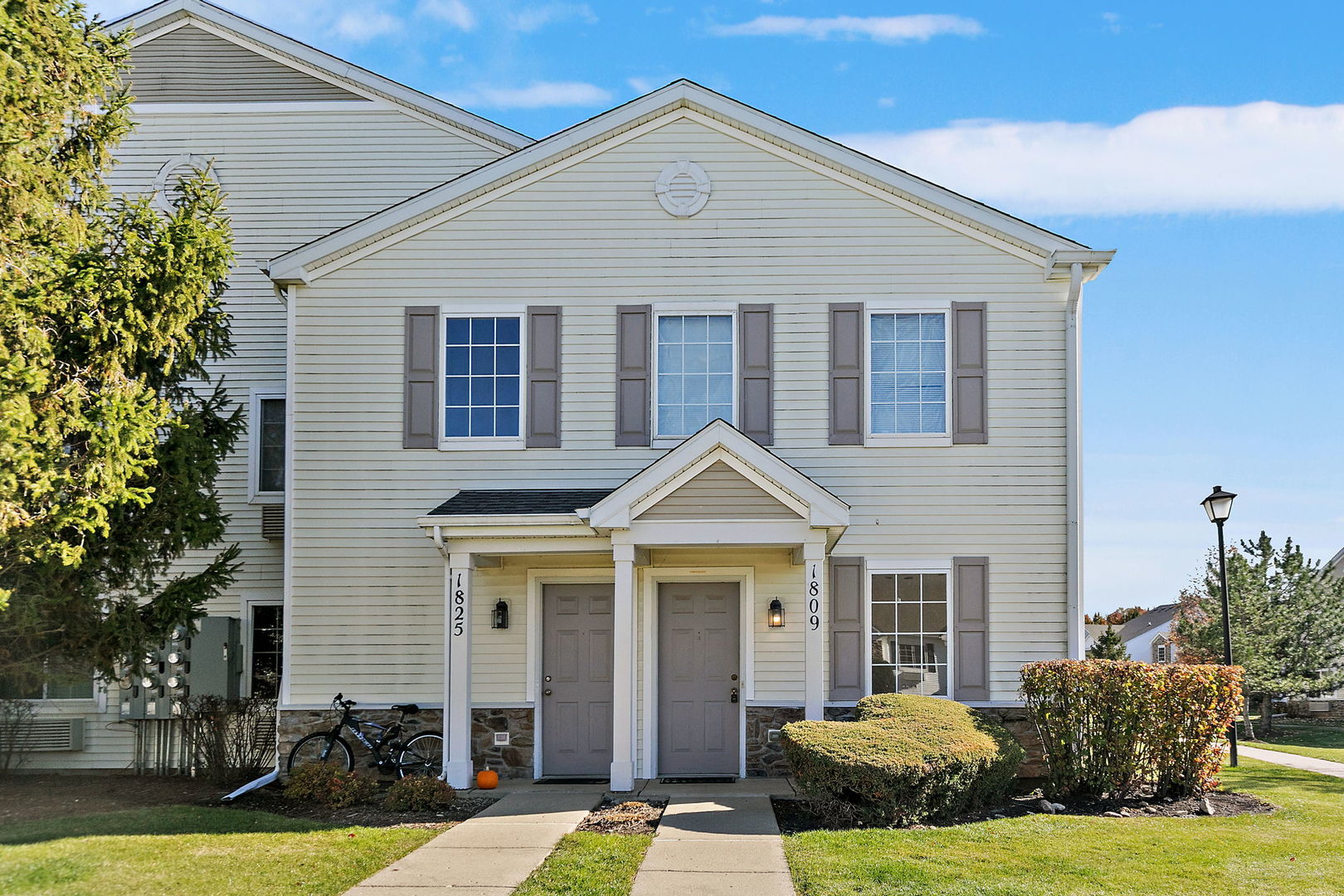 1809 Silverstone Drive, Unit 1809 Carpentersville, IL 60110 - Photo 1 of 17 a view of a white house next to a yard with potted plants