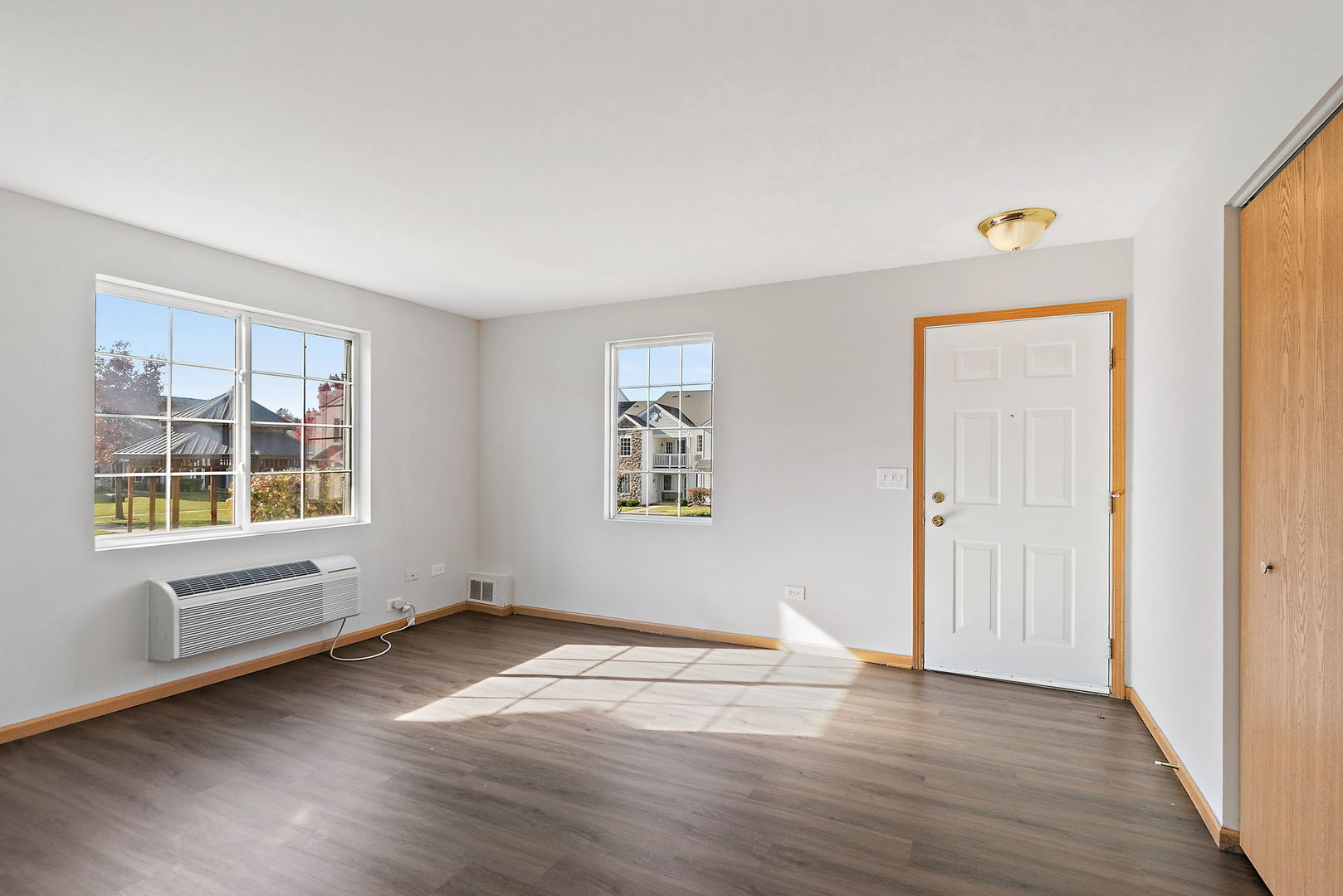 1809 Silverstone Drive, Unit 1809 Carpentersville, IL 60110 - Photo 3 of 17 an empty room with wooden floor and windows