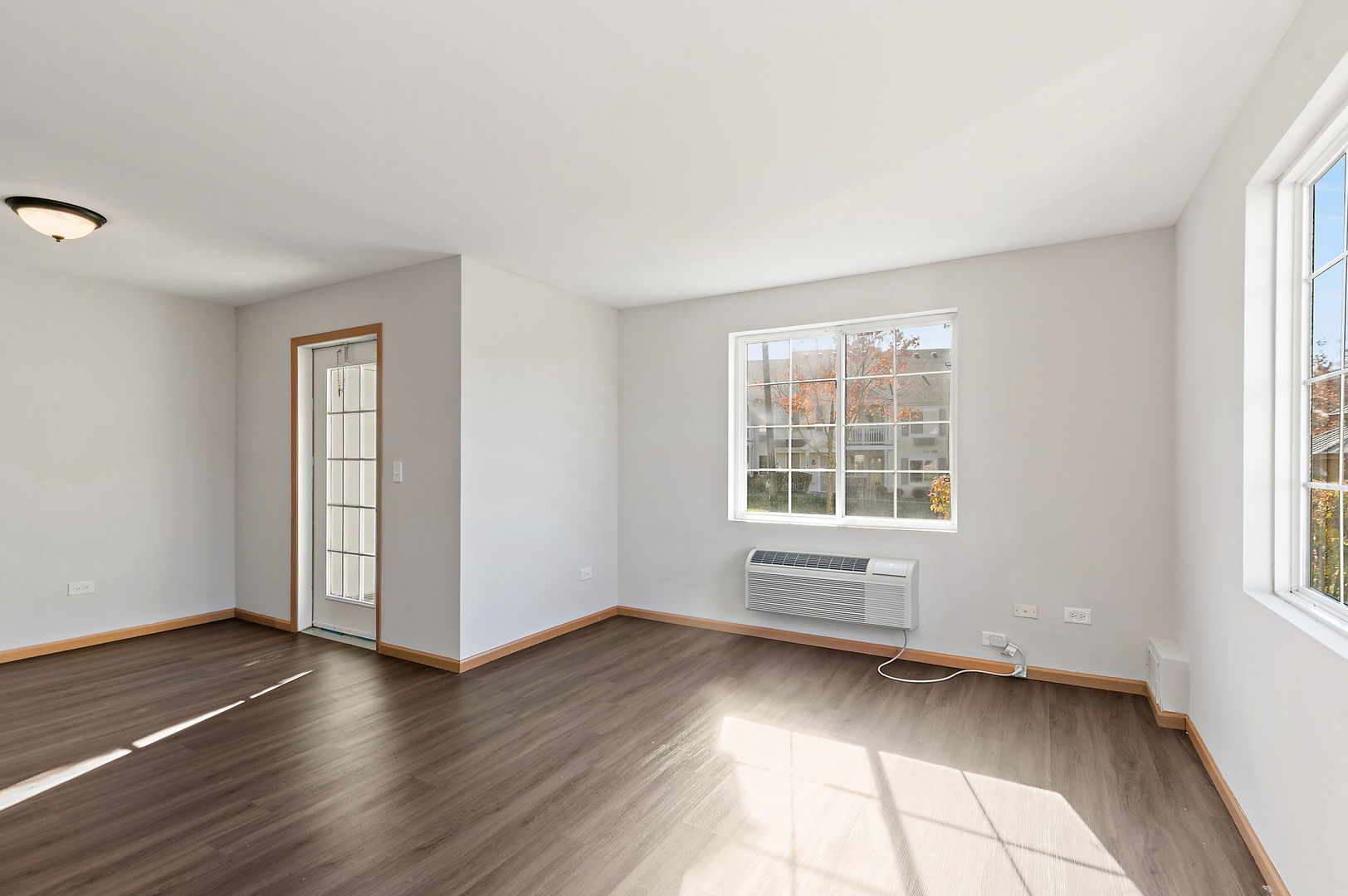 1809 Silverstone Drive, Unit 1809 Carpentersville, IL 60110 - Photo 4 of 17 an empty room with wooden floor and windows