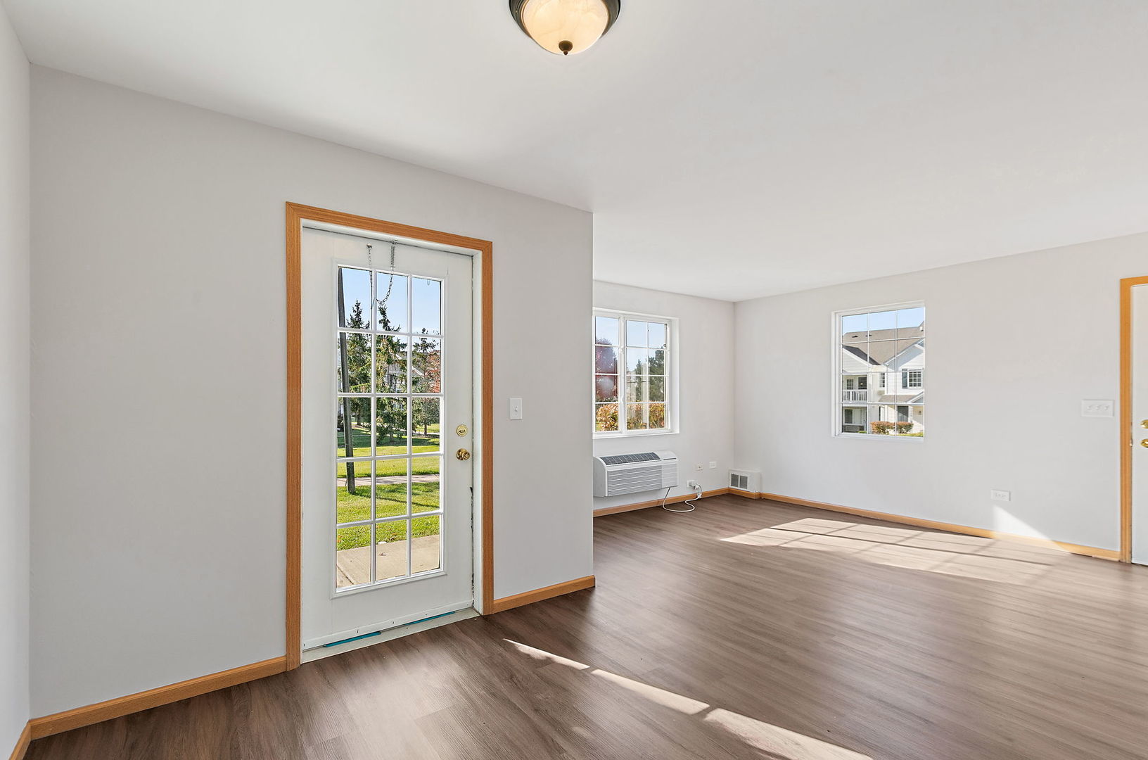 1809 Silverstone Drive, Unit 1809 Carpentersville, IL 60110 - Photo 6 of 17 a view of an empty room with a window and wooden floor