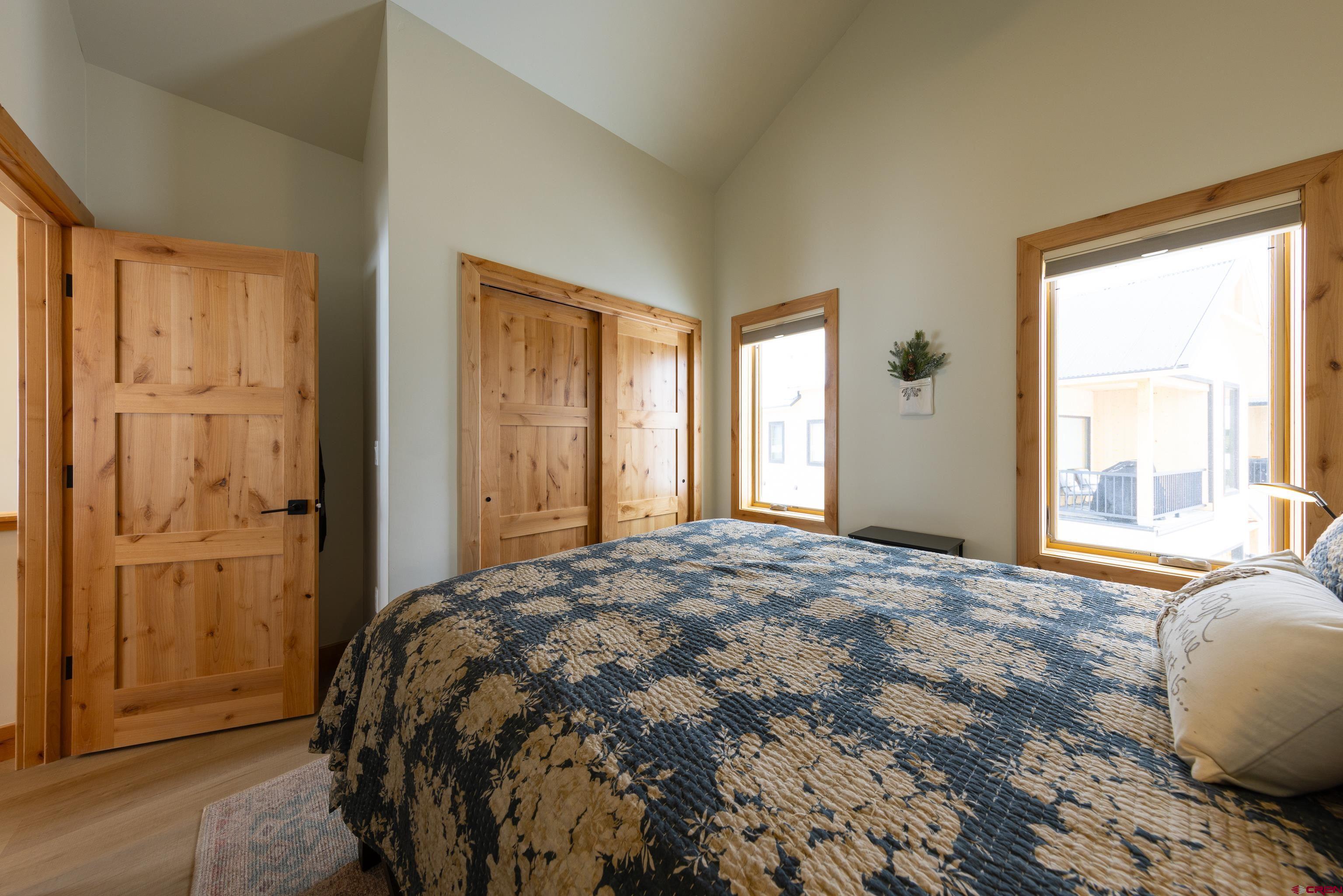 101 Elk Valley Road, Unit B Crested Butte, CO 81224 - Photo 22 of 33 a bed sitting in a spacious bedroom next to a window and a chair