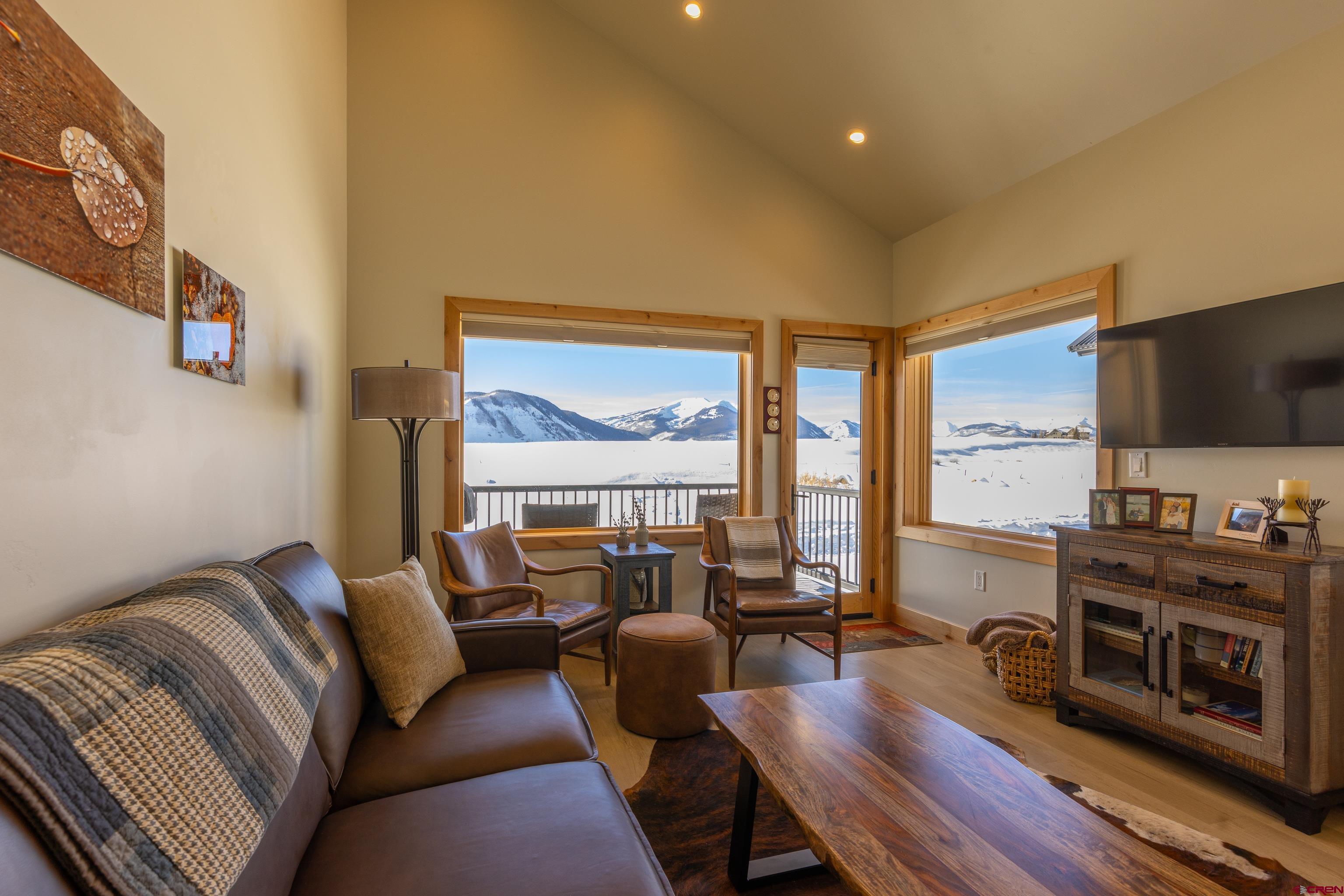 101 Elk Valley Road, Unit B Crested Butte, CO 81224 - Photo 10 of 33 a living room with furniture a flat screen tv and a floor to ceiling window