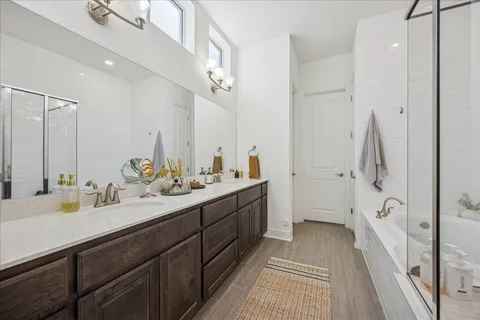 a spacious bathroom with a tub shower and a sink