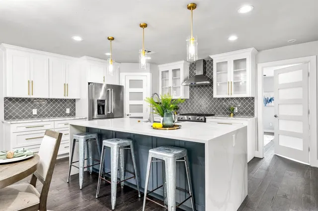 a kitchen with stainless steel appliances kitchen island granite countertop a table chairs sink and cabinets