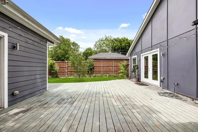 a view of empty room with window and wooden floor