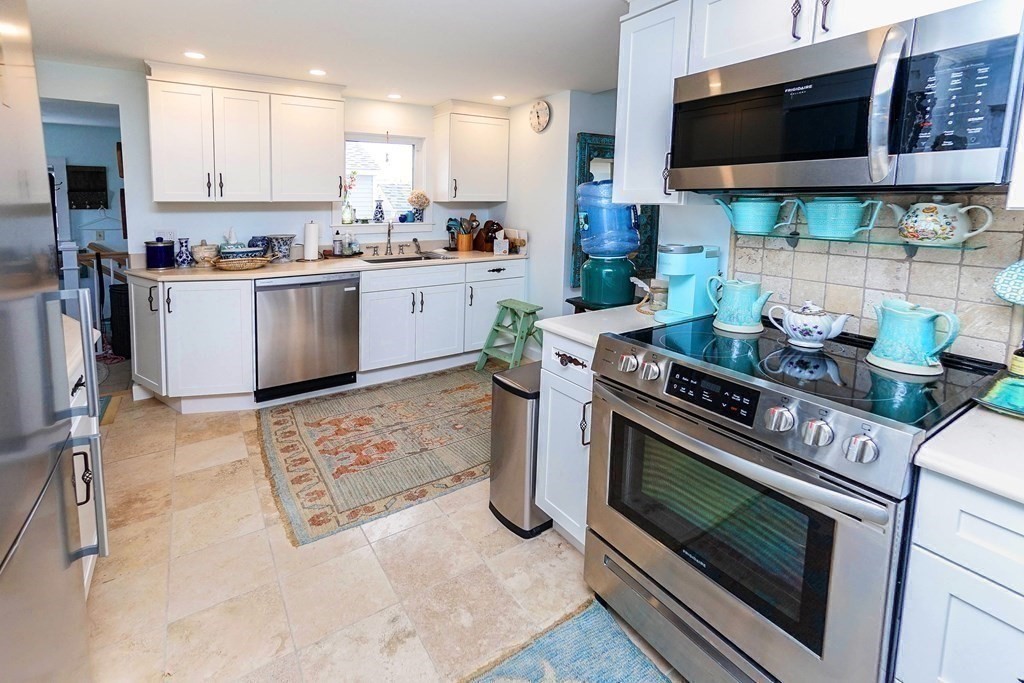 11 Harbor Street Newburyport, MA 01950 - Photo 13 of 39 a kitchen with stainless steel appliances a stove a microwave a sink and cabinets