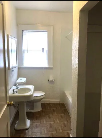 a bathroom with a sink toilet and mirror